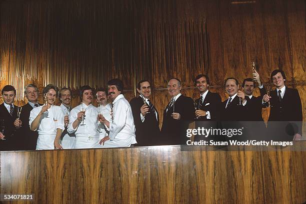 Group portrait of some of the staff of the Four Seasons Hotel as they raise glasses of champagne, New York, New York, February 1982.