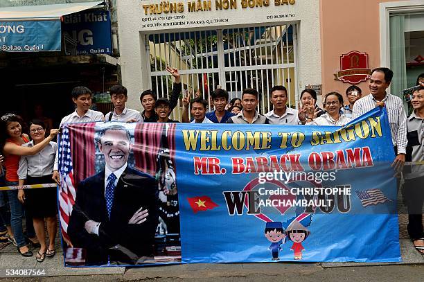 People hold a banner as they line up the streets to catch a glimpse of US President Barack Obama on his way to the airport at the end of two-day...