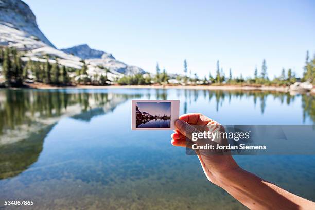 A woman holding a polaroid picture.