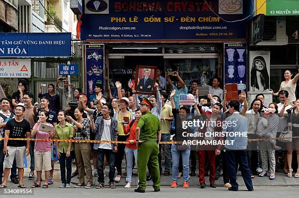 People line up the streets to catch a glimpse of US President Barack Obama on his way to the airport at the end of two-day visit to Ho Chi Minh City...