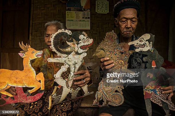 Ibrahim with his wife Rugiyem show shadow puppets in Wukirsari, Imogiri, Bantul, Yogyakarta, Indonesia on May 23, 2016. Shadow puppets are made of...