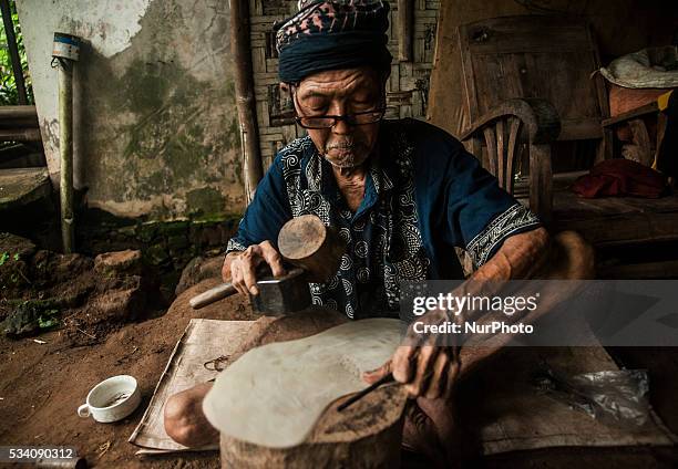Ibrahim making shadow puppets in Wukirsari, Imogiri, Bantul, Yogyakarta, Indonesia on May 23, 2016. Shadow puppets are made of buffalo skin an...