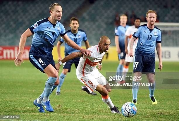 Shandong Luneng player Diego Tardelli Martins evades the tackle of Sydney FC player Zac Anderson as David Carney looks on during their AFC Champions...