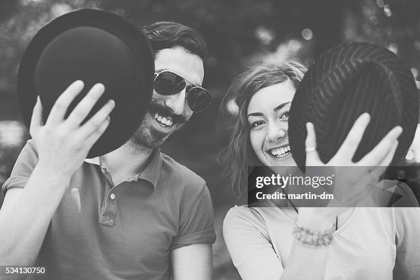 happy couple looking at camera - hiding from selfie stockfoto's en -beelden