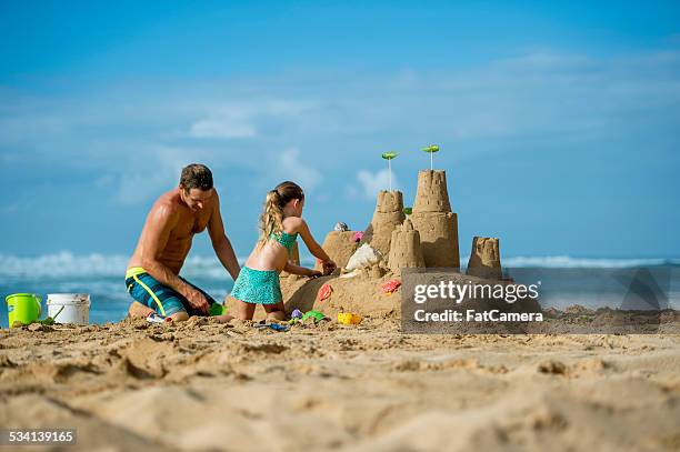 father and daughter family building sand castle on beach - beach holiday stock pictures, royalty-free photos & images