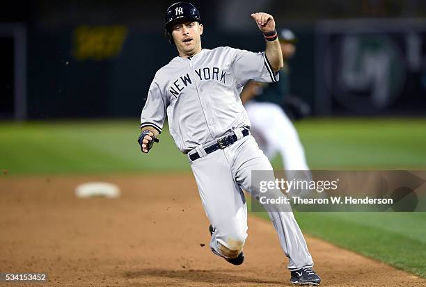 Dustin Ackley of the New York Yankees slides into third base safe against the Oakland Athletics in the top of the six inning at O.co Coliseum on May...