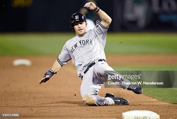 Dustin Ackley of the New York Yankees slides into third base safe against the Oakland Athletics in the top of the six inning at O.co Coliseum on May...