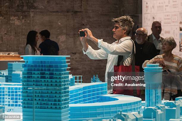 Alejandro Aravena, curator of the 15th Architecture Venice Biennale, looks at the installations of the Reporting from the Front pavillon on May 25,...