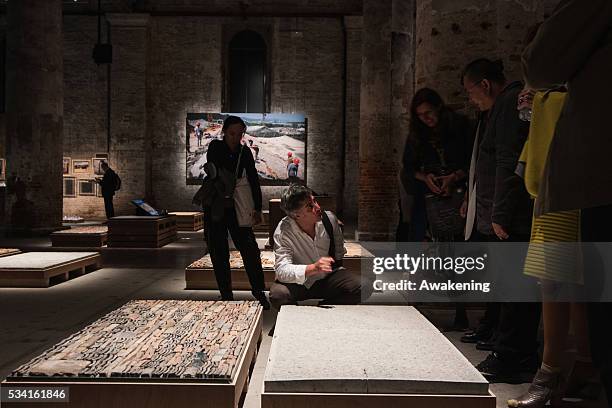 Alejandro Aravena, curator of the 15th Architecture Venice Biennale, looks at the installations of the Reporting from the Front pavillon on May 25,...