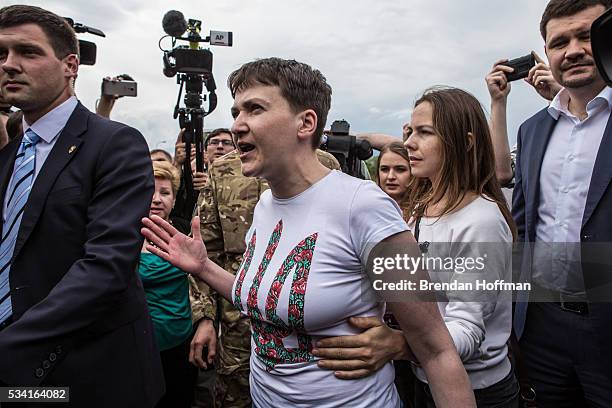 Ukrainian military pilot Nadiya Savchenko is held back by her sister, Vira Savchenko, while surrounded by media upon her arrival at Kyiv Boryspil...