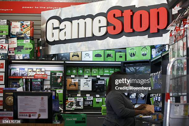 Signage is displayed as as an employee works at a GameStop Corp. Store in West Hollywood, California, U.S., on Sunday, May 22, 2016. GameStop Corp....