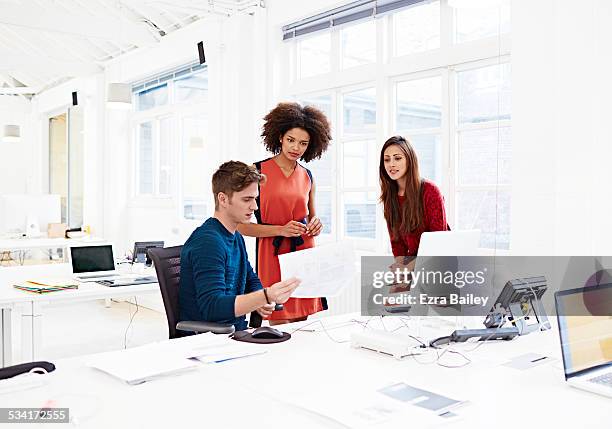 meeting in a creative open plan office - red office chair stock pictures, royalty-free photos & images