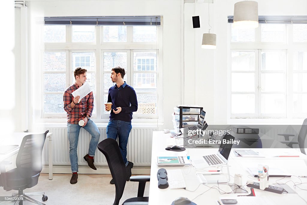 Two creatives chatting in open plan office