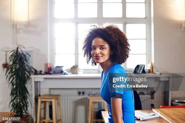 portrait of a creative woman in loft apartment. - business woman blue stockfoto's en -beelden