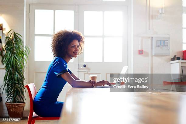 woman working at home in trendy apartment. - blue dress stock pictures, royalty-free photos & images