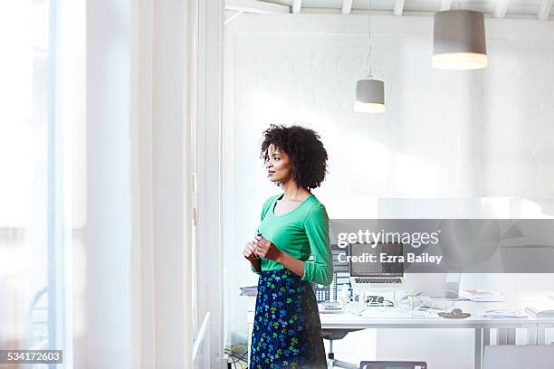 businesswoman staring out the window thinking. - jupe verte photos et images de collection