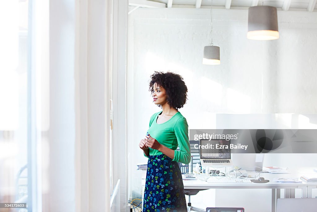 Businesswoman staring out the window thinking.