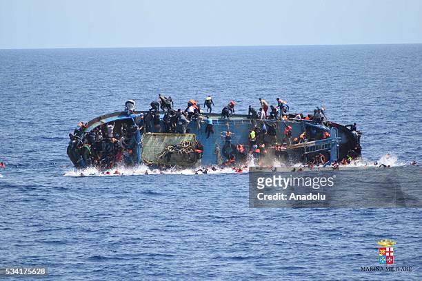 Migrants in an overcrowded boat, which was about to capsize, are rescued by Bettica and Bergamini ships of Italian Navy at Sicilian Strait, between...