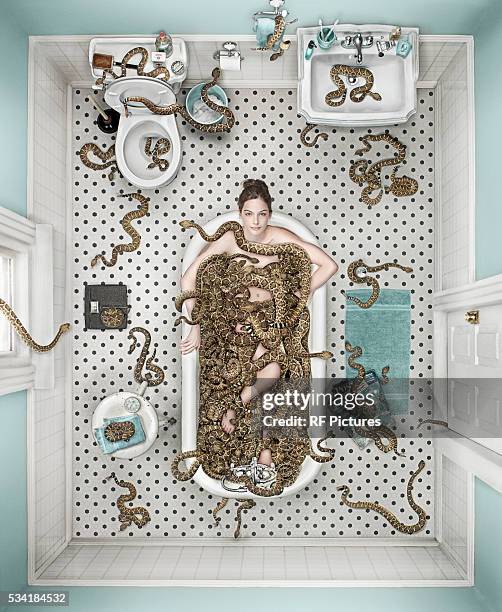 woman sitting in bathtub with rattlesnakes - large group of animals stock pictures, royalty-free photos & images