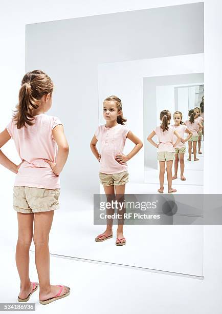 girl (4-5) looking into her reflections in mirror - girl in mirror stockfoto's en -beelden