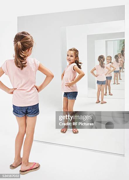 girl (4-5) looking into her reflections in mirror - bottomless girls stockfoto's en -beelden