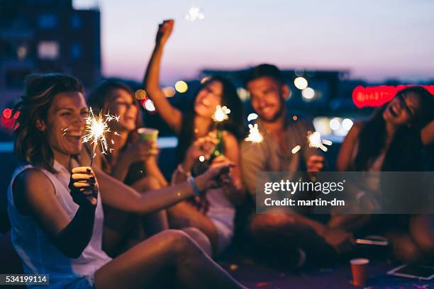 best friends on a rooftop party - rooftop at night stock pictures, royalty-free photos & images