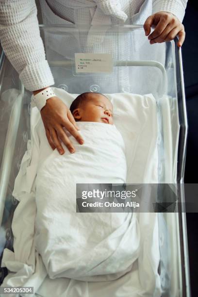 ragazzino neonato che dorme in ospedale una culla - lettino ospedale foto e immagini stock