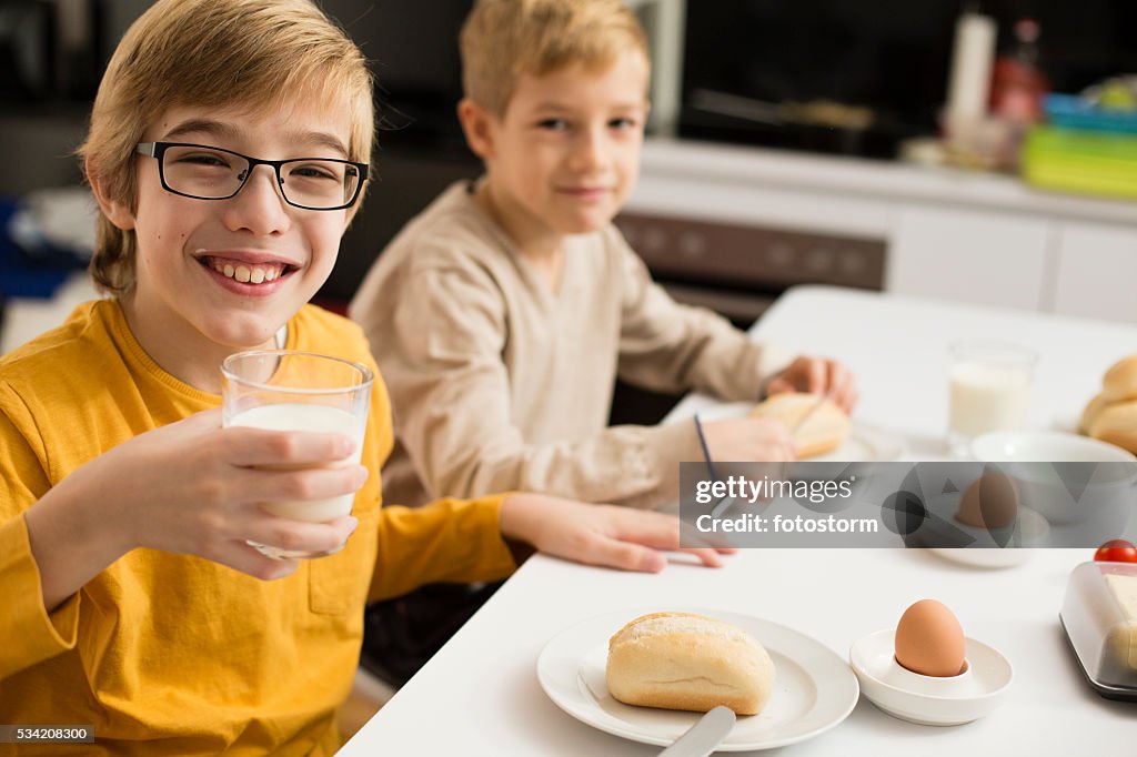 Kinder essen Frühstück, trinken Milch in der Küche