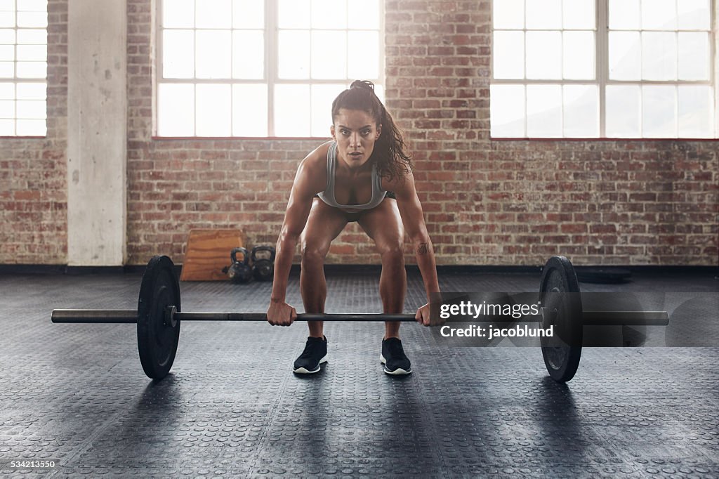 Female performing deadlift exercise with weight bar
