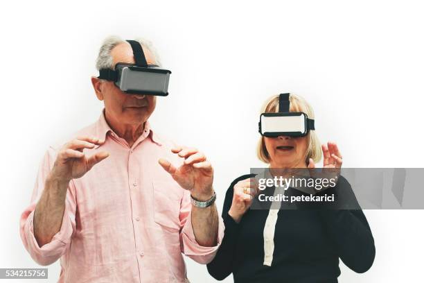 senior couple wearing virtual reality headset, paris, france - hands free apparaat stockfoto's en -beelden