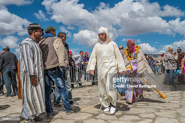 Having signed official betrothal papers, husband and wife to-be walk from the registrar's tent at the Imilchil, Morocco Marriage and Betrothal...