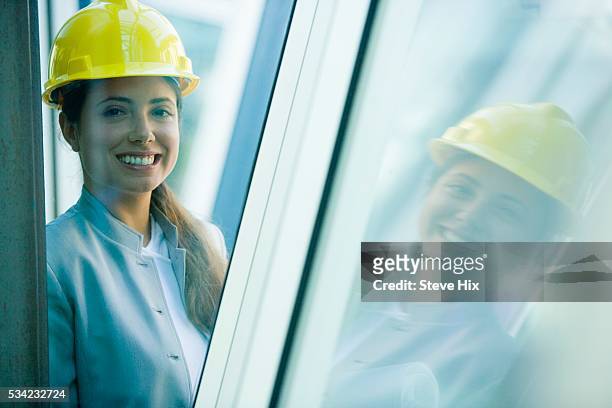 female architect in a hard hat between glass walls - metallic blazer stock pictures, royalty-free photos & images