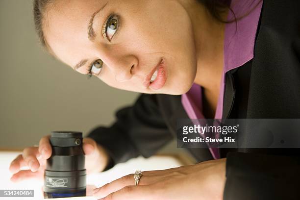 woman examining slides - lightbox stock-fotos und bilder