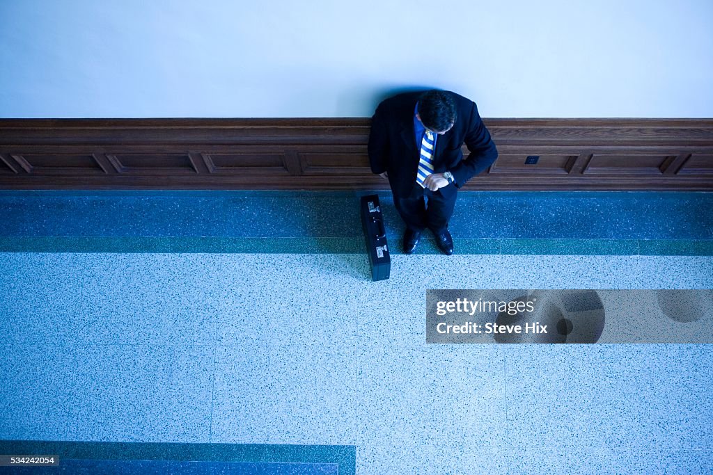 Businessman Leaning Against Wall