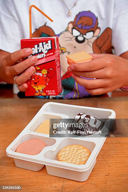 Northeast grade school student sits down to lunch with juice box and lunchables.