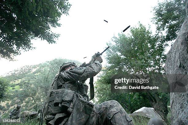 Soldiers from Charlie Company, U.S. Army 10th Mountain Division return fire from Taliban insurgents positioned on a ridge-line near the town of...