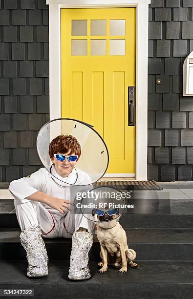 portrait of boy (13-15) and dog wearing protective collar - safety funny fotografías e imágenes de stock