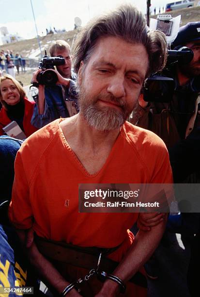 Surrounded by the media and other, Theodore Kaczynski, aka the Unabomber, is escorted to a court for arraignment, April 4, 1996. Kaczynski later pled...