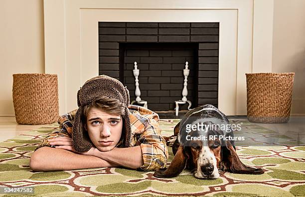 portrait of teenager (13-15) and dog laying on carpet - caricatura fotografías e imágenes de stock
