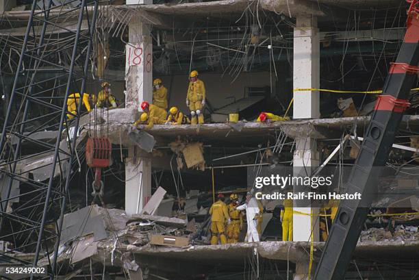 Rescue workers and industrial cranes sift through the rubble of the destroyed Federal Building in the aftermath of the Oklahoma City bombing. On...