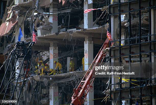 Rescue workers and industrial cranes sift through the rubble of the destroyed Federal Building in the aftermath of the Oklahoma City bombing. On...