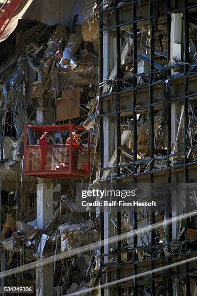 Rescue workers are lifted in a basket to reach the higher floors of the destroyed Federal Building in the aftermath of the Oklahoma City bombing. On...