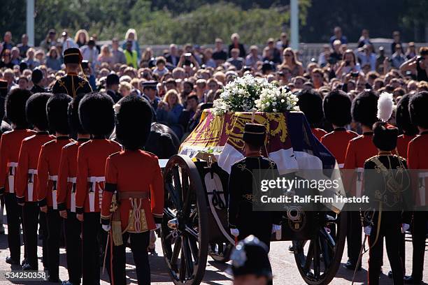Mourners watch as the Queen's Life Guard escorts the coffin of Diana, Princess of Wales outside Buckingham Palace during her funeral.