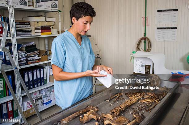 Aiming for exact identification, a forensic anthropologist examines the nearly complete skeleton of a Bosnia war victim, at the International...