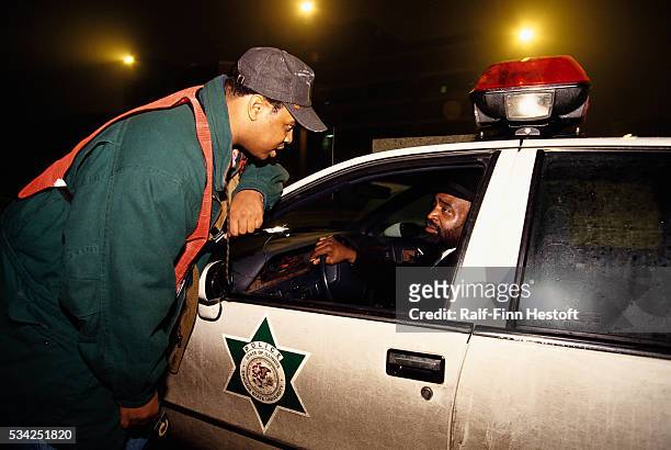 Security officer Nayes leans down to speak with Police Chief Albert D. Cheeser at Chicago State University. The two officers are part of the...