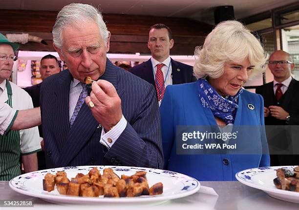 Prince Charles, Prince of Wales and Camilla, Duchess of Cornwall try a selection of sausages inside McGettigans Butchers store on May 25, 2016 in...