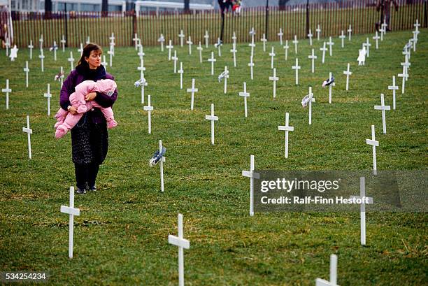 Woman taking part in a pro-life march walks among grave markers with her child in Washington, DC. On January 22 the anniversary of the Roe v. Wade...
