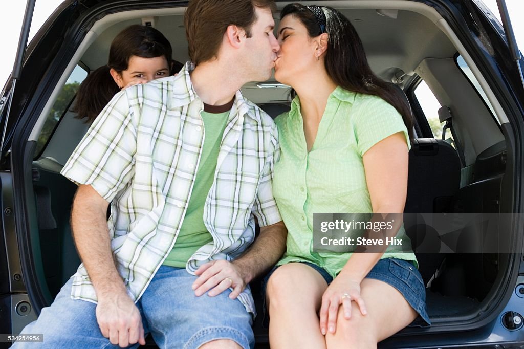 Couple Kissing While Daughter Watches