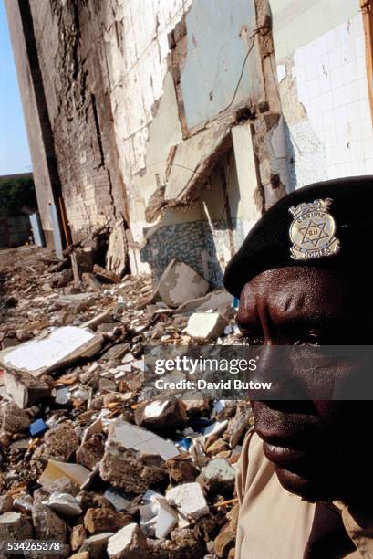 Security guard watches over the remains of the United States embassy, after the bombing.