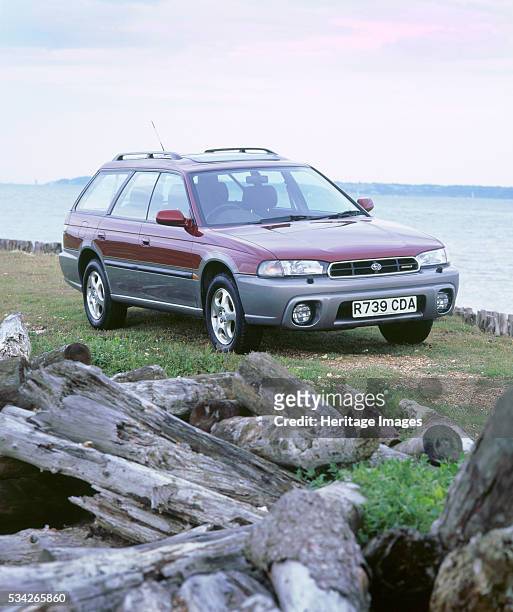 Subaru Legacy Outback on beach, 2000.